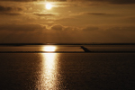 Salin de Giraud. Coucher de soleil sur les barrages des salines; le phare de Faraman &agrave; gauche (&agrave; l`horizon).